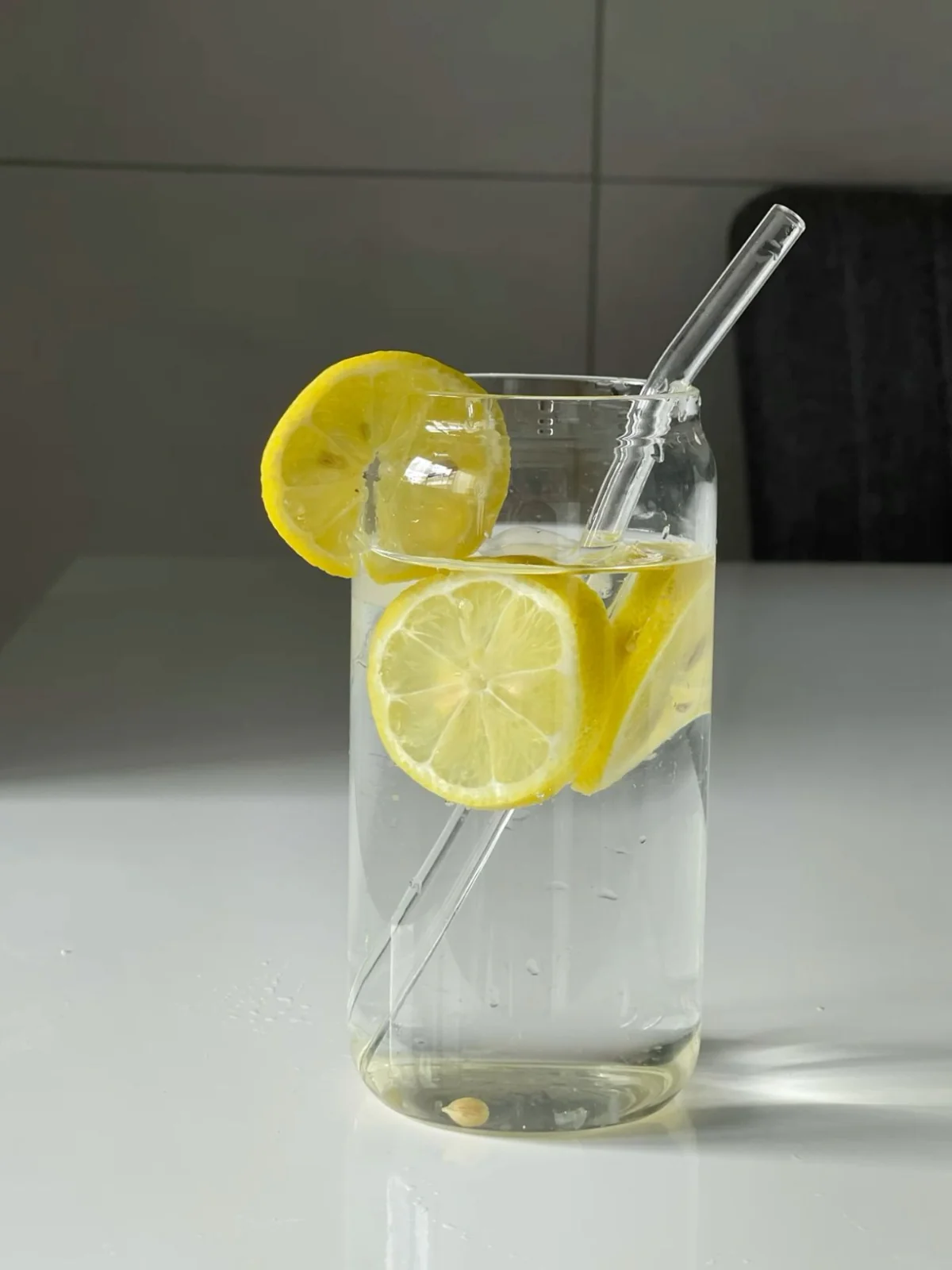 Eau citronnée dans un verre avec paille en verre - hydratation saine