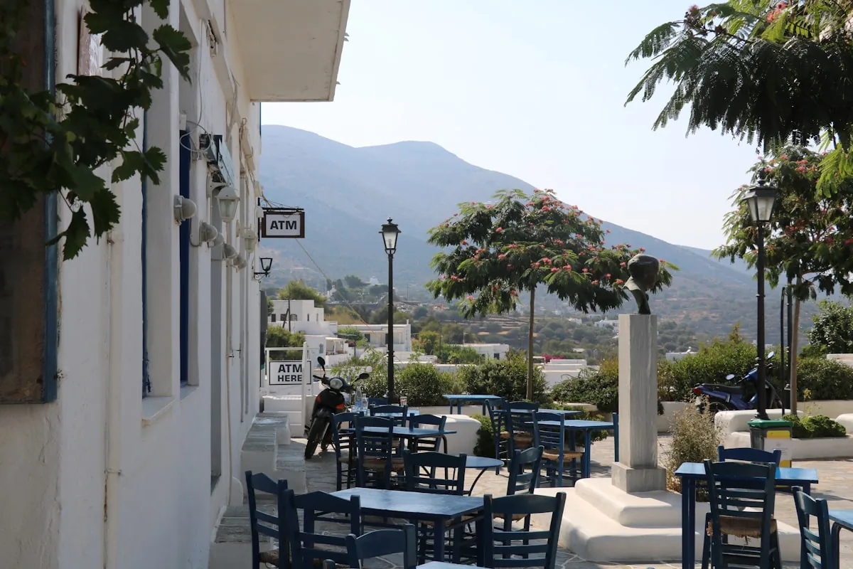 Terrasse de restaurant méditerranéen, tables et chaises bleues face à la mer
